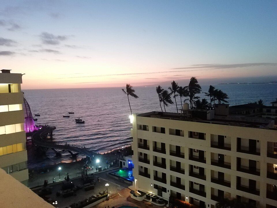 Atardecer sobre un hotel frente al mar en el malecón de Puerto Vallarta